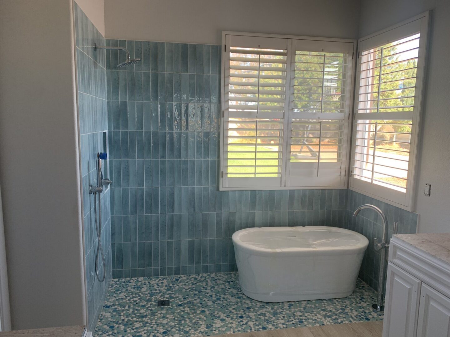 Modern bathroom with a freestanding tub and glass shower enclosure.