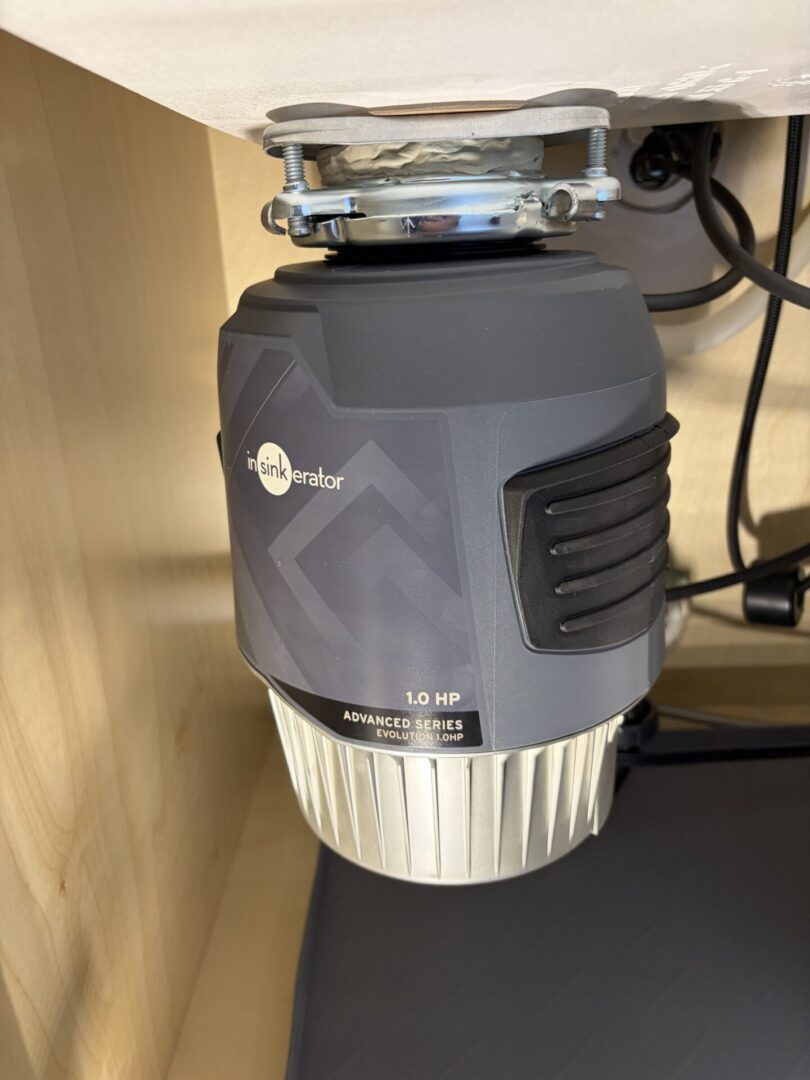Garbage disposal mounting and drain connections under a kitchen sink